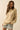 Model front-facing wearing embroidered tiger sweater in soft neutral knit.