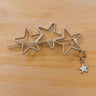 Tivoli Hair Clip with silver star design on light wood background, playful accessory photo for Matte.