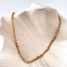 Gold chain necklace against a light background