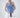 Woman wearing a denim vest and white pants with a plain background