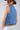 Woman wearing a blue denim crop top against a plain background