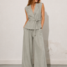 Woman wearing the Wilkin Set in a soft sage linen-blend fabric, featuring a tailored sleeveless vest, high-waisted wide-leg pants, relaxed fit, breathable woven texture, and an effortlessly elegant silhouette.