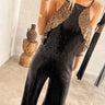 Woman wearing black and gold sequin halter jumpsuit — luxury evening outfit.
